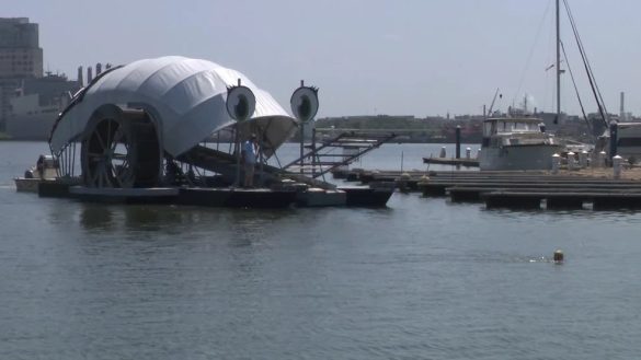 Professor Trash Wheel returns to Baltimore Inner Harbor with swimmer Katie Pumphrey after receiving a new barge for its Canton cleanup post.
