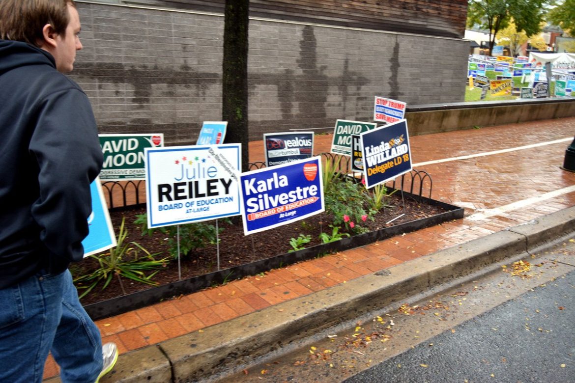 Voter walks past campaign signs outside an early voting site in Takoma Park, Maryland
